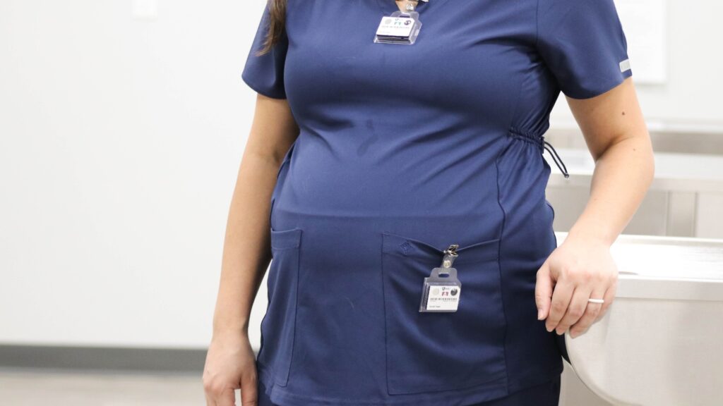 A pregnant employee wears a TLD badge and a fetal dosimeter.