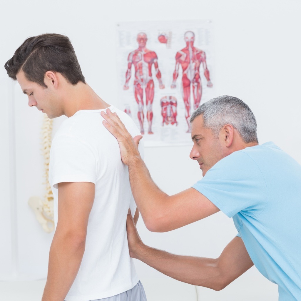 A chiropractor completes an initial exam with a patient.