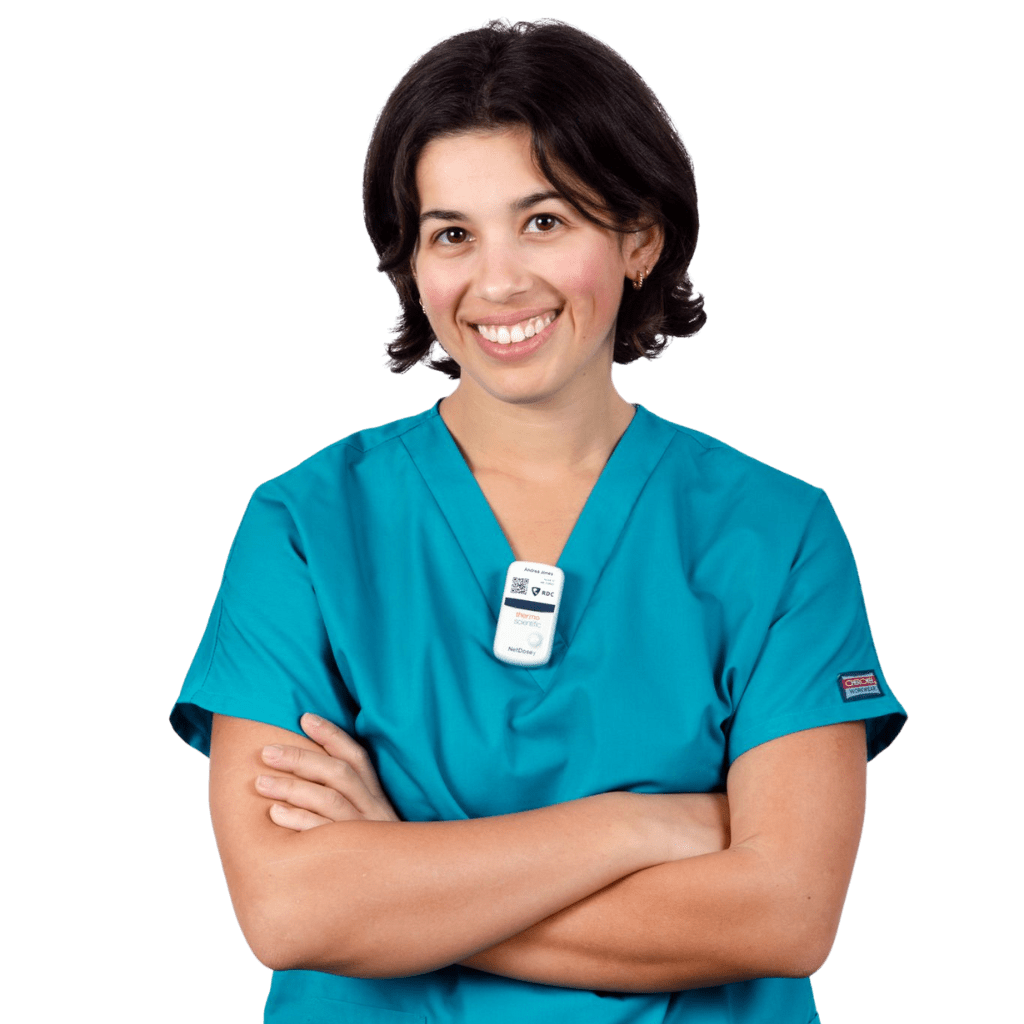 A healthcare worker wears a digital dosimeter clipped to her scrubs.