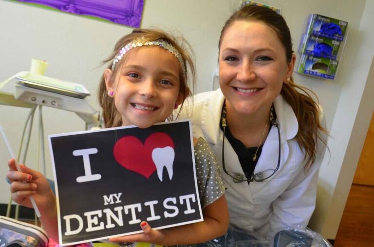 A young patient smiles with a dentist after a successful appointment.
