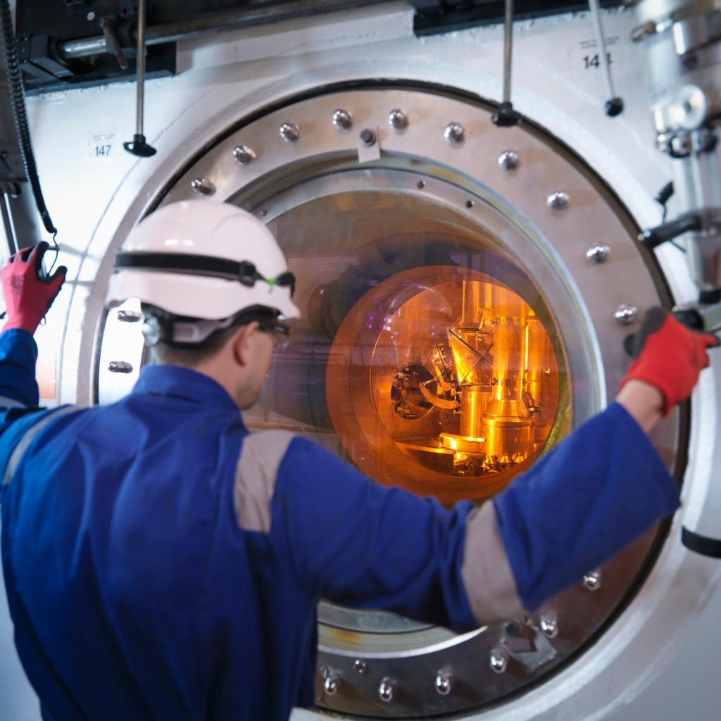 A nuclear worker monitors a fuel rod in an energy station.