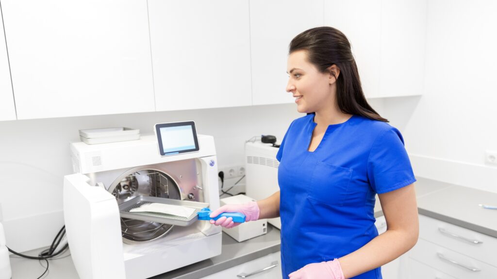 A dental technician sterilizes equipment.