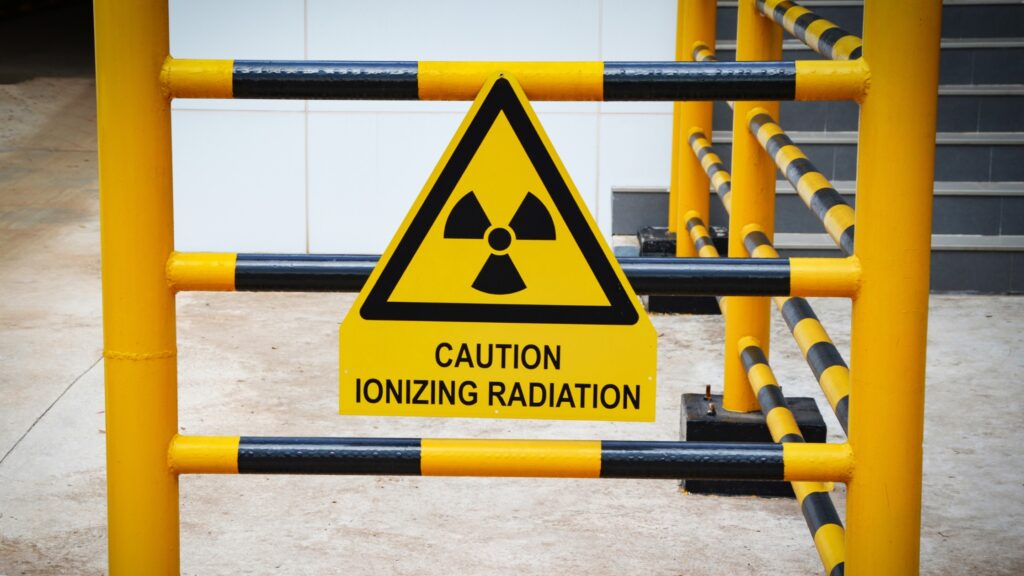 A yellow and black divider with a triangular sign that reads "CAUTION IONIZING RADIATION"