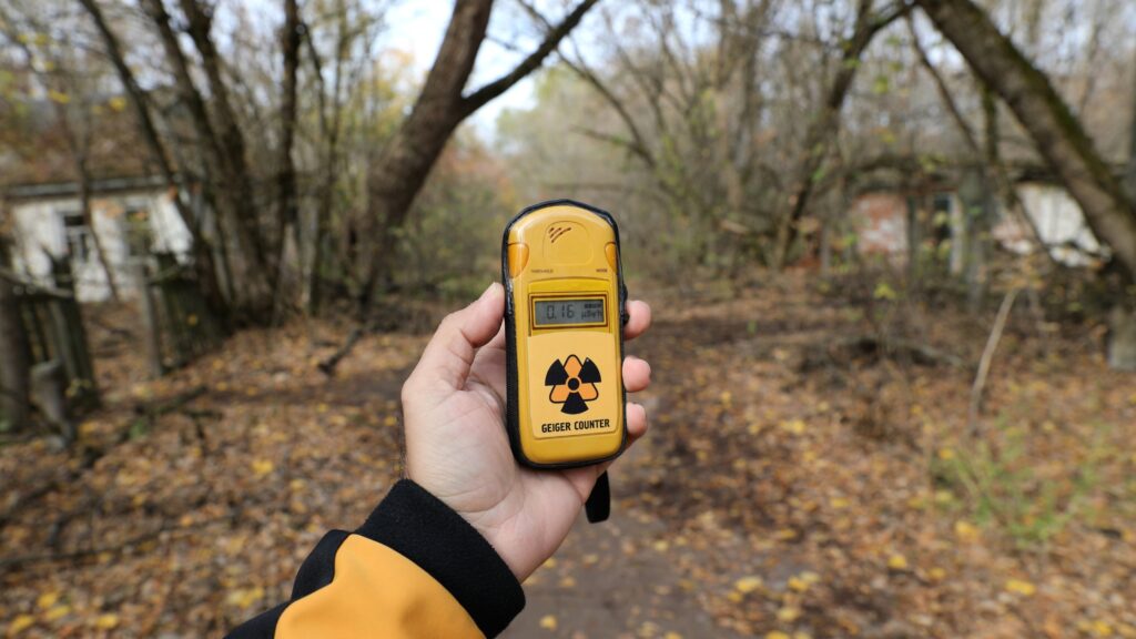 A person uses a Geiger counter to detect radiation.