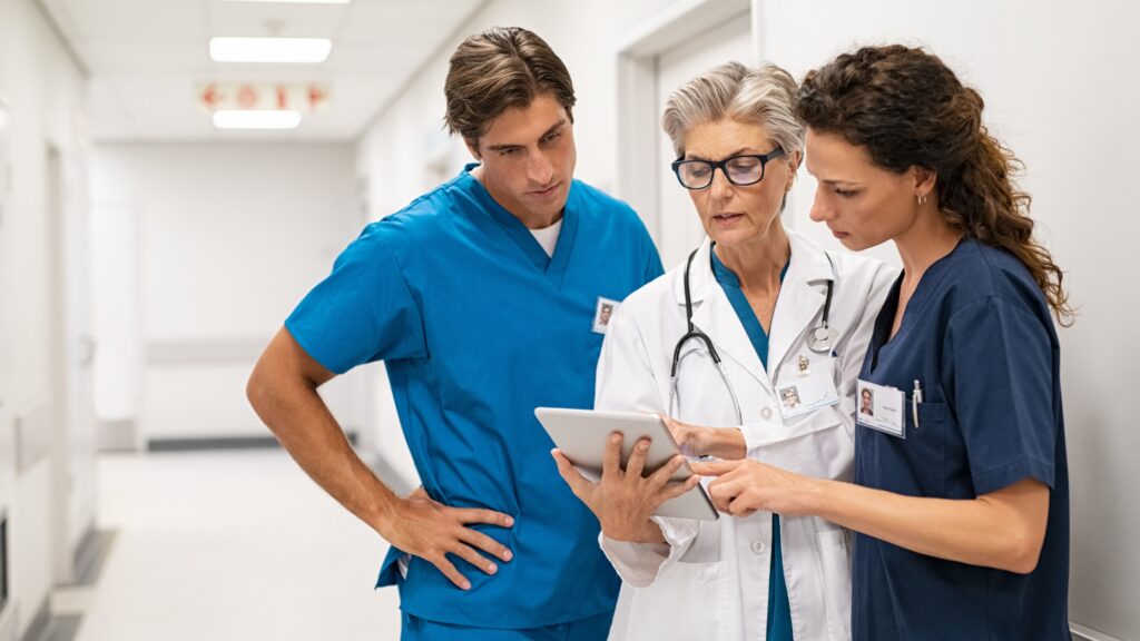 A team of healthcare workers considers radiation monitoring services on a tablet.