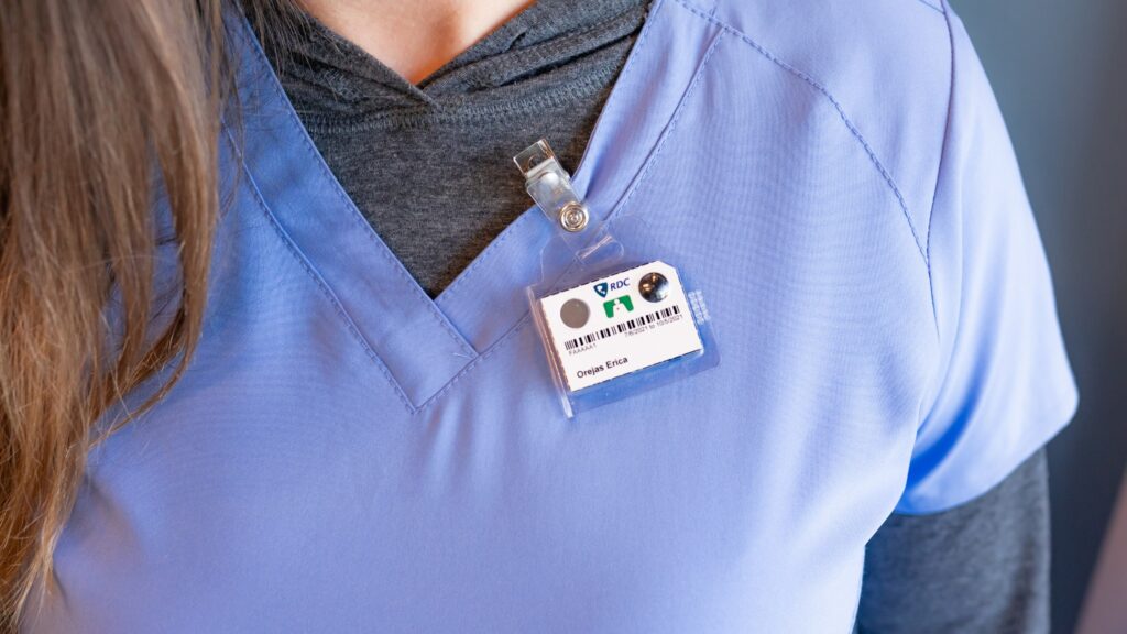 A person wears one of the whole body TLD personal dosimeters for diagnostic radiology.