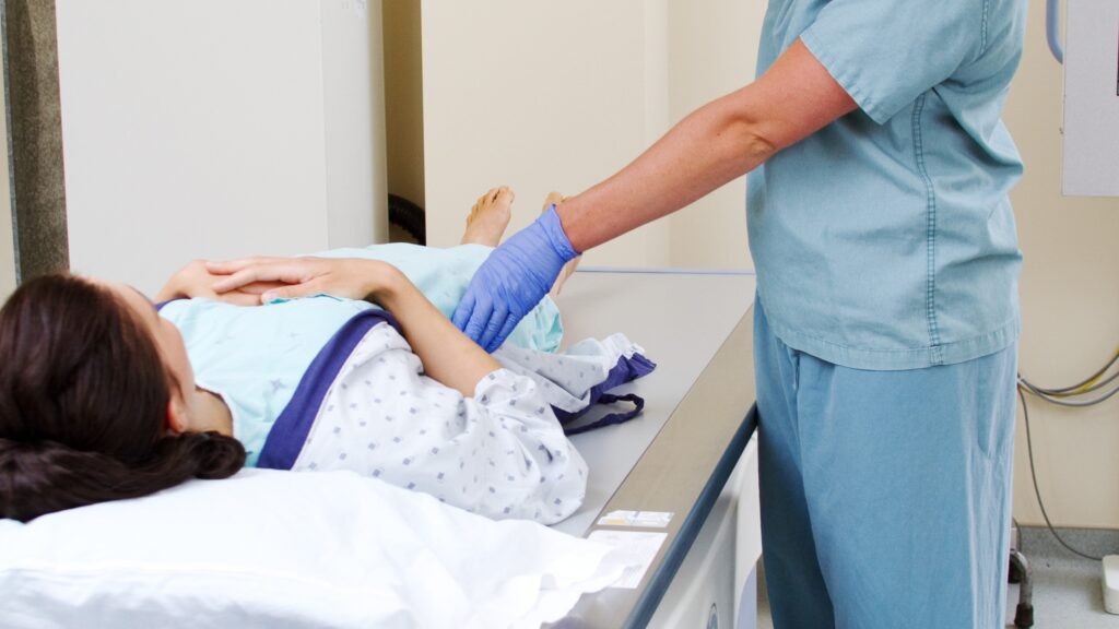 An X-ray technician prepares a patient for an imaging session.