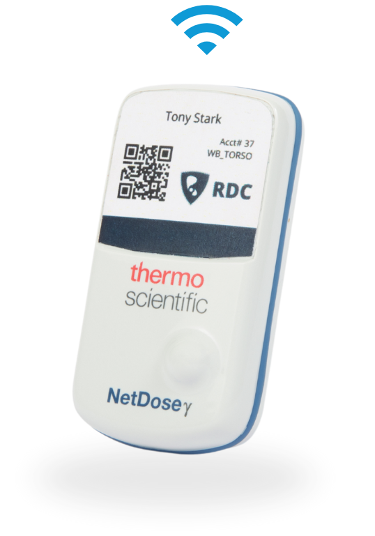 A white NetDose dosimeter by Thermo Scientific features a screen displaying a QR code, the name Tony Stark, and a Wi-Fi symbol above, indicating wireless connectivity.