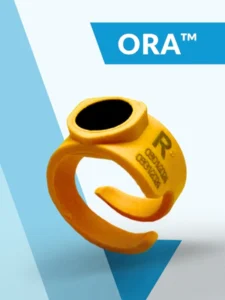A yellow plastic ring with “R” and serial numbers printed on it, displayed on a white and blue background with the text “ORA™” in the top right corner.
