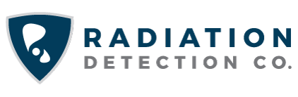 Logo for Radiation Detection Co. featuring a blue shield with white abstract shapes on the left, and company name in bold blue and gray capital letters to the right on a light background.