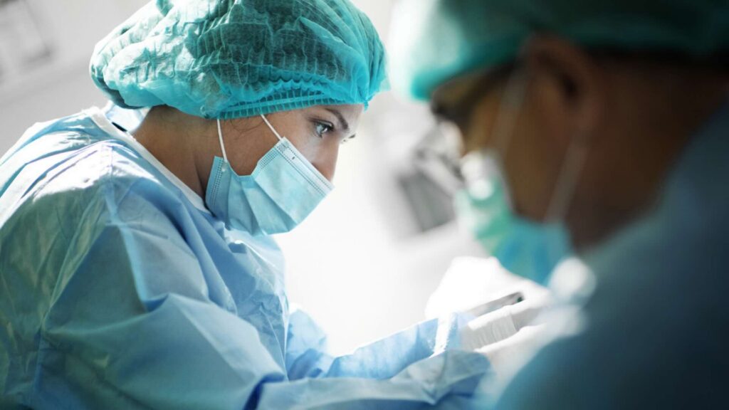 A surgeon with a compromised posture completes a procedure.