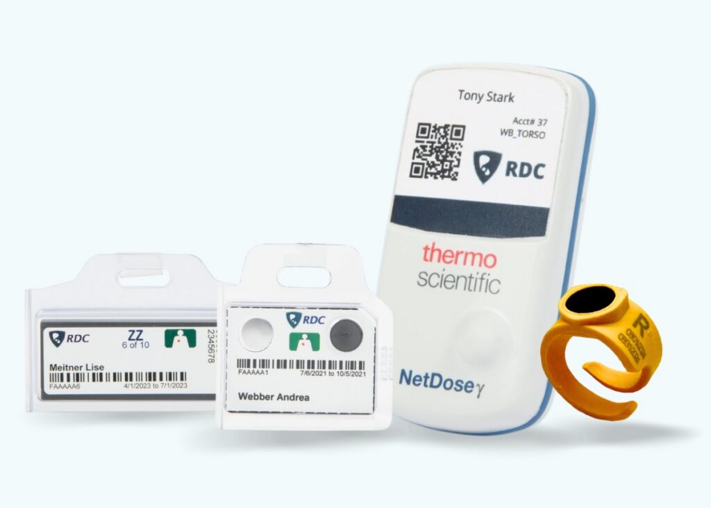 The image showcases dosimeters (including TLD, OSL, NetDose digital dosimeter, and ORA OSL ring) on a light blue background.