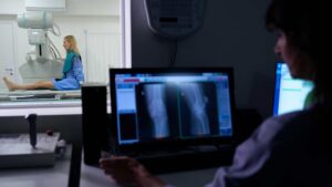 An imaging technician captures X-rays for a patient.